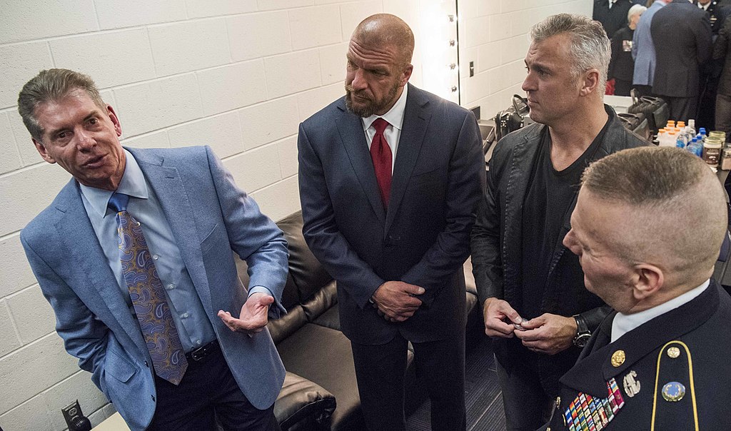 WWE CEO Vince McMahon, Paul "Triple H" Levesque, and Shane McMahon speak to Army Command Sgt. Maj. John W. Troxell.