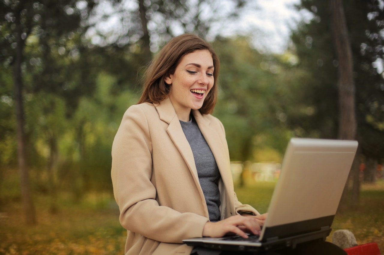 Woman smiling while typing on her laptop.