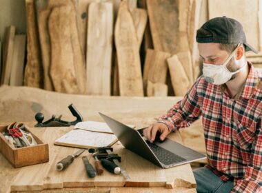 Man using computer in woodworking shed.