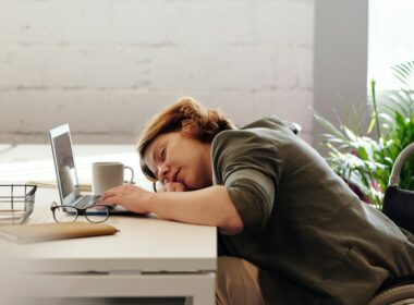 Woman sleeping at her desk on her computer.