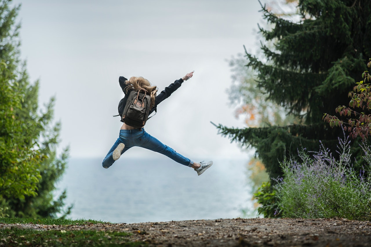 Happy woman jumping in the forest.