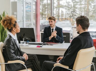 Man in a suit talking to customers in an office.