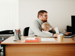 Man taking care of his son while working from home.