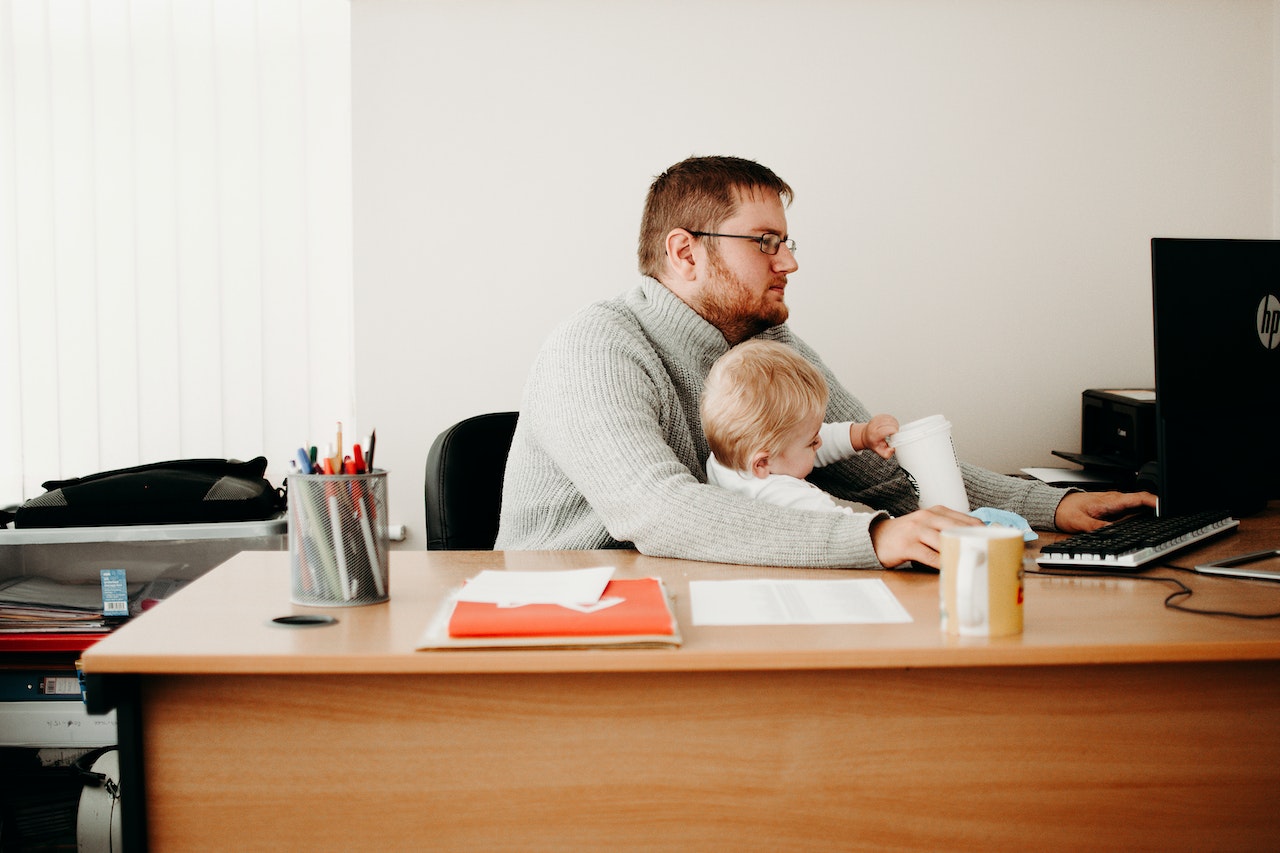 Man taking care of his son while working from home.