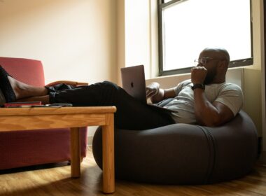Black man working from home sitting on a beanbag.