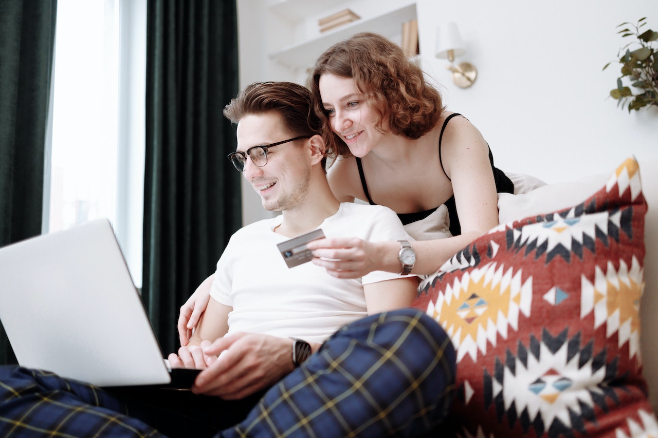 Man and woman making online shopping purchase at home