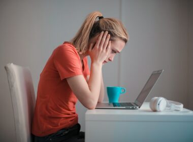 Woman looking distressed reading laptop computer at home