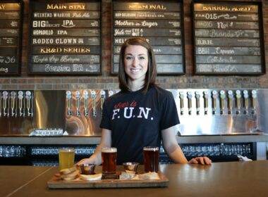 Woman bartender standing in front of beer and food