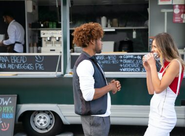 Man and woman eating at a food truck.