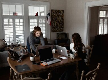 Two women working and using laptops at their dining room table
