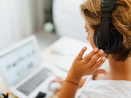 Woman wearing headphones on her computer