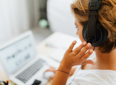Woman wearing headphones on her computer
