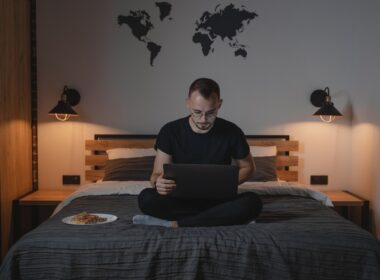 Man using laptop while sitting on bed