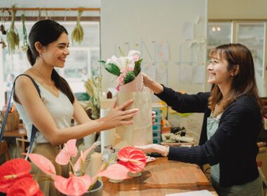Florist giving bouquet of flowers to woman customer.