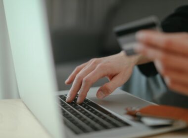 Person's fingers making an online purchase with credit card