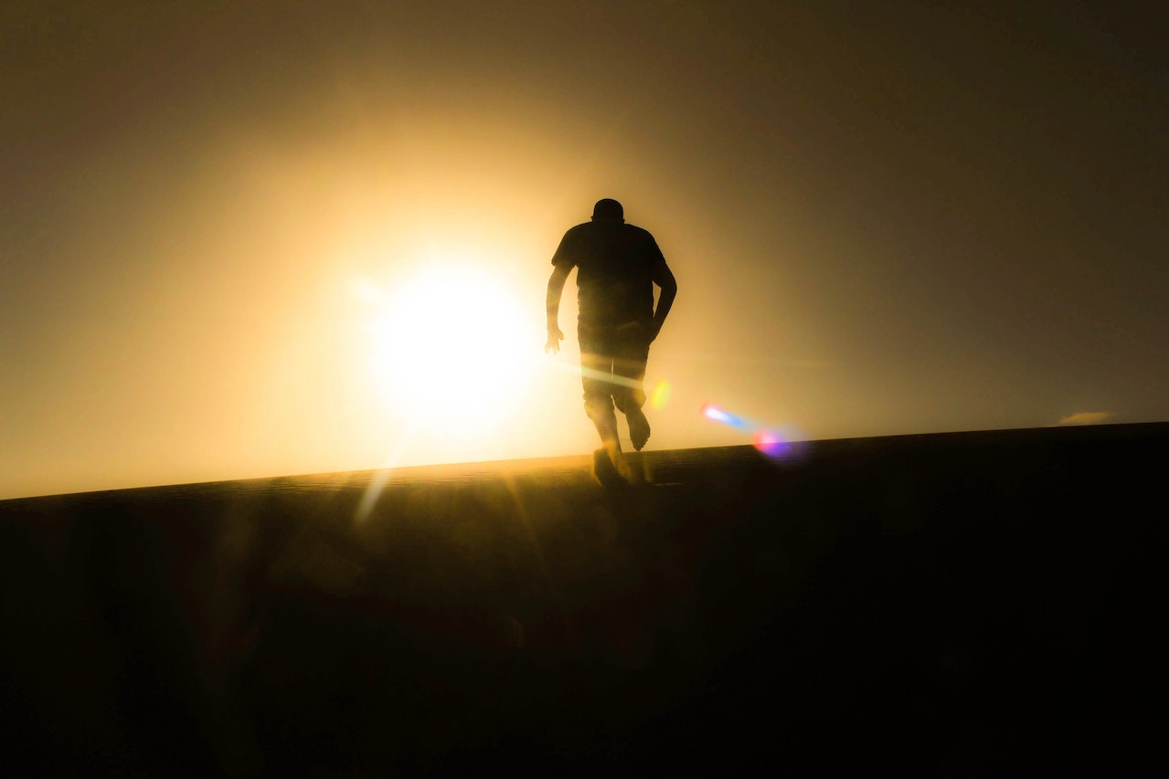 Silhouette of man running uphill