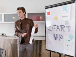 Young man in front of a whiteboard explaining a project