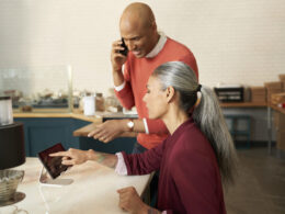 Young woman and man on phone looking at laptop in a promo photo for Verizon Small Business