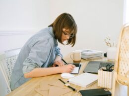 Woman working at a table with laptop in home
