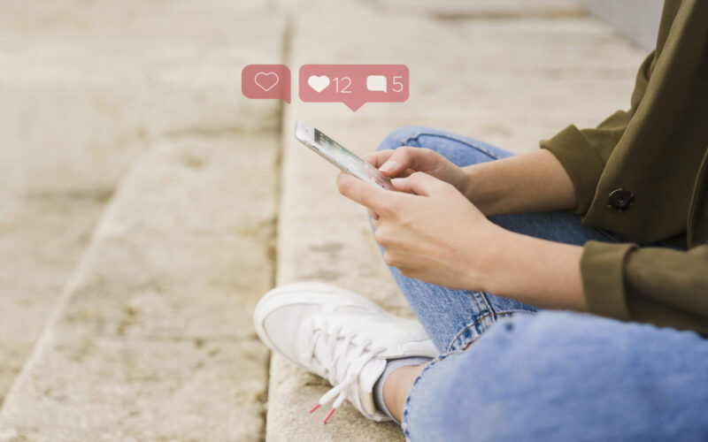 Woman sitting cross legged with smart phone looking at social media Image by Freepik