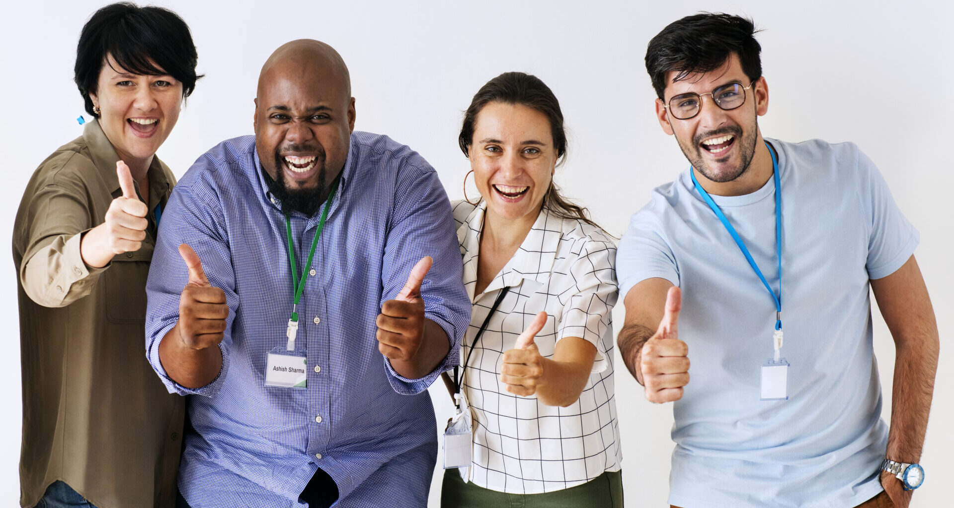 Four employees smiling and showing thumbs up appreciation