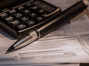 Pen and calculator with tax documents in an image by Image by vecstock on Freepik