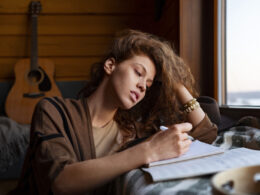 Woman writing in a journal with musical instruments in an Image by Freepik