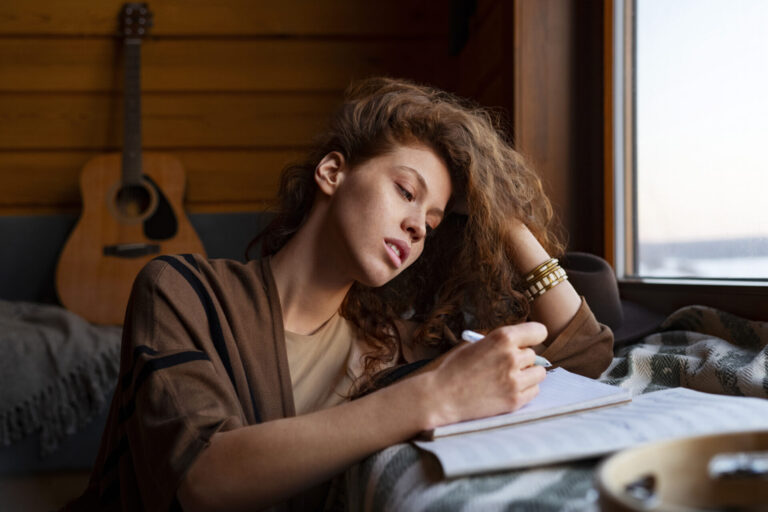 Woman writing in a journal with musical instruments in an Image by Freepik
