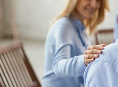 WOman putting hand on shoulder in empathetic gesture