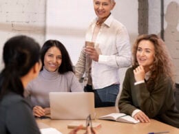 Woman holding coffee and communicating with colleagues in a work setting