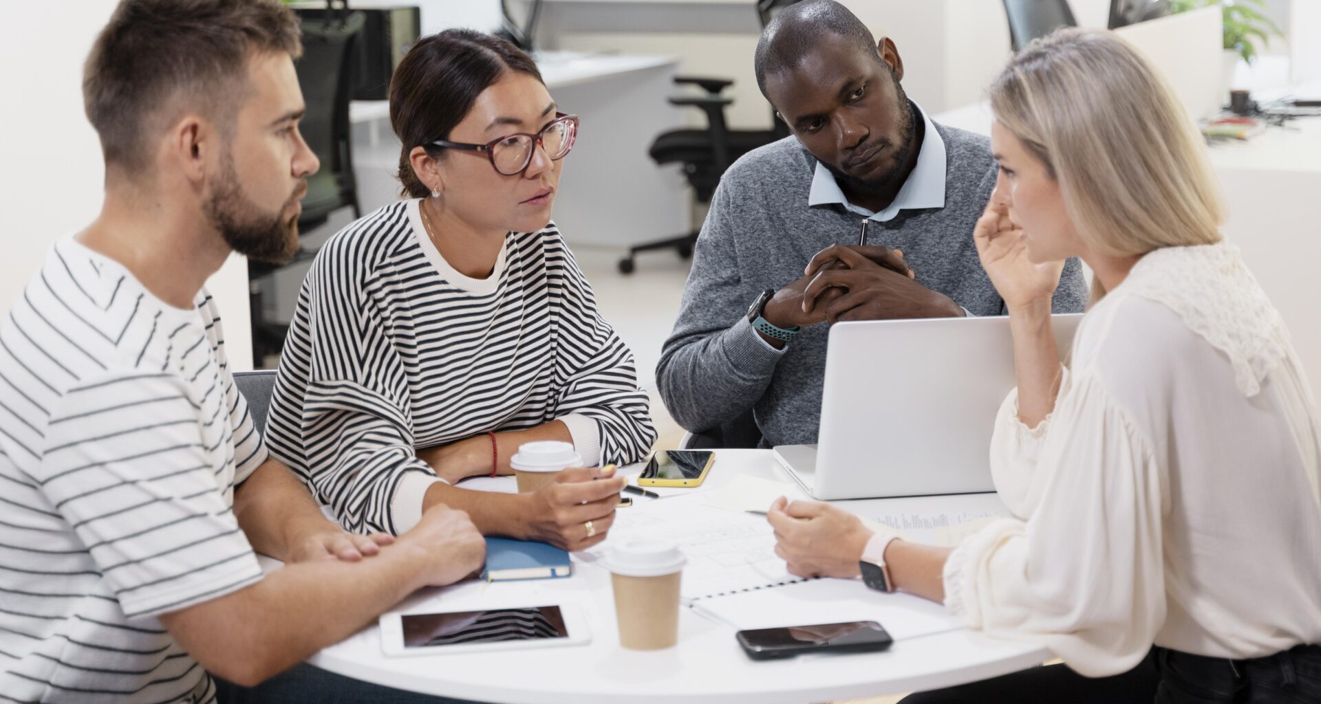 young colleagues having a meeting around a desk and a laptop