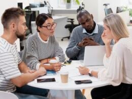 young colleagues having a meeting around a desk and a laptop