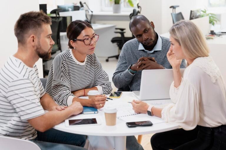 young colleagues having a meeting around a desk and a laptop