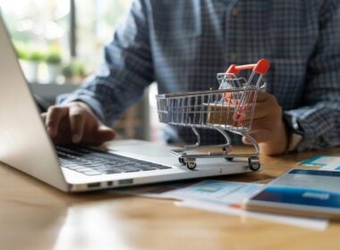 Person setting up an online store, uploading products on a laptop