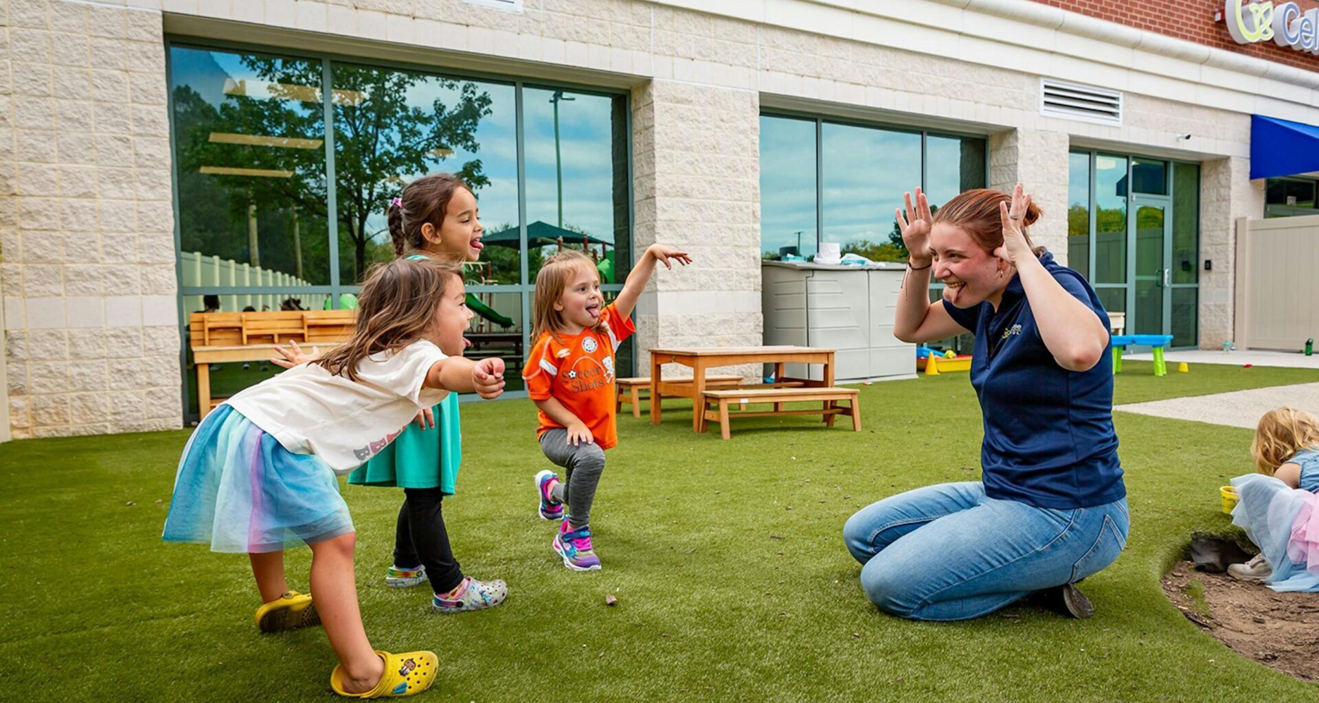 Teacher and children playing outside child care center