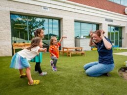 Teacher and children playing outside child care center