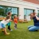 Teacher and children playing outside child care center