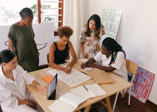 Young colleagues gathered around a work table going over project plans