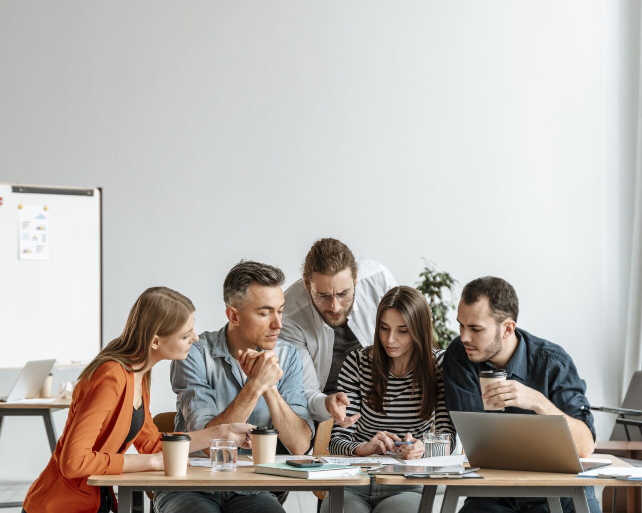 Young office colleagues gathered around a table working on a project together.