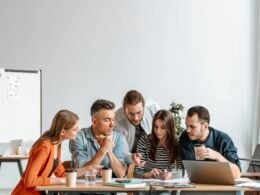 Young office colleagues gathered around a table working on a project together.